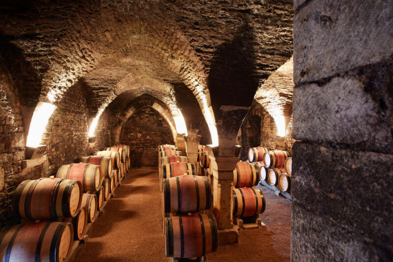 cave remplie de tonneaux de vins et illuminée à chablis