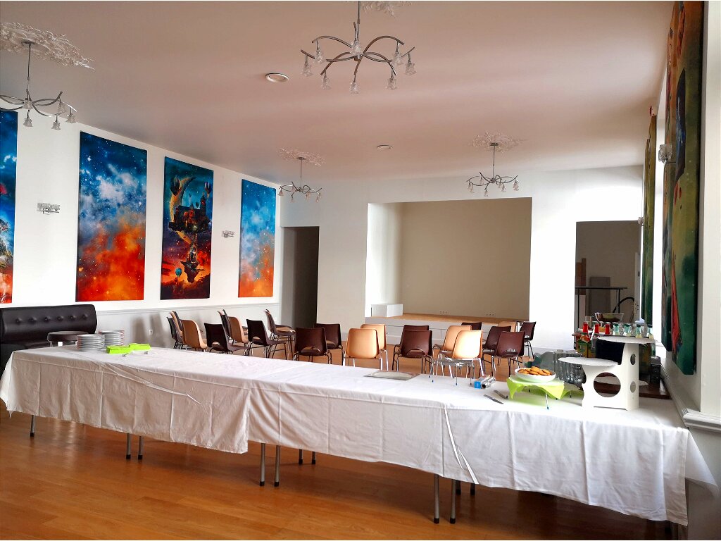 salle de reception a Tonnerre avec table de buffet, chaises et scene et une décoration murale