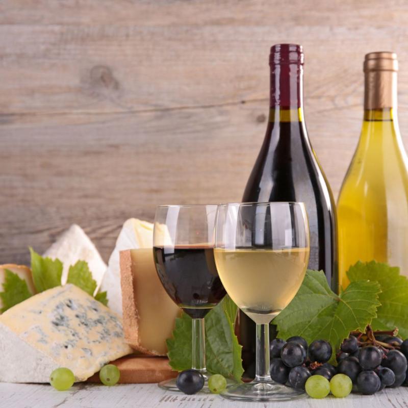 assortiment de vin rouge et de vin blanc avec un plateau de fromage